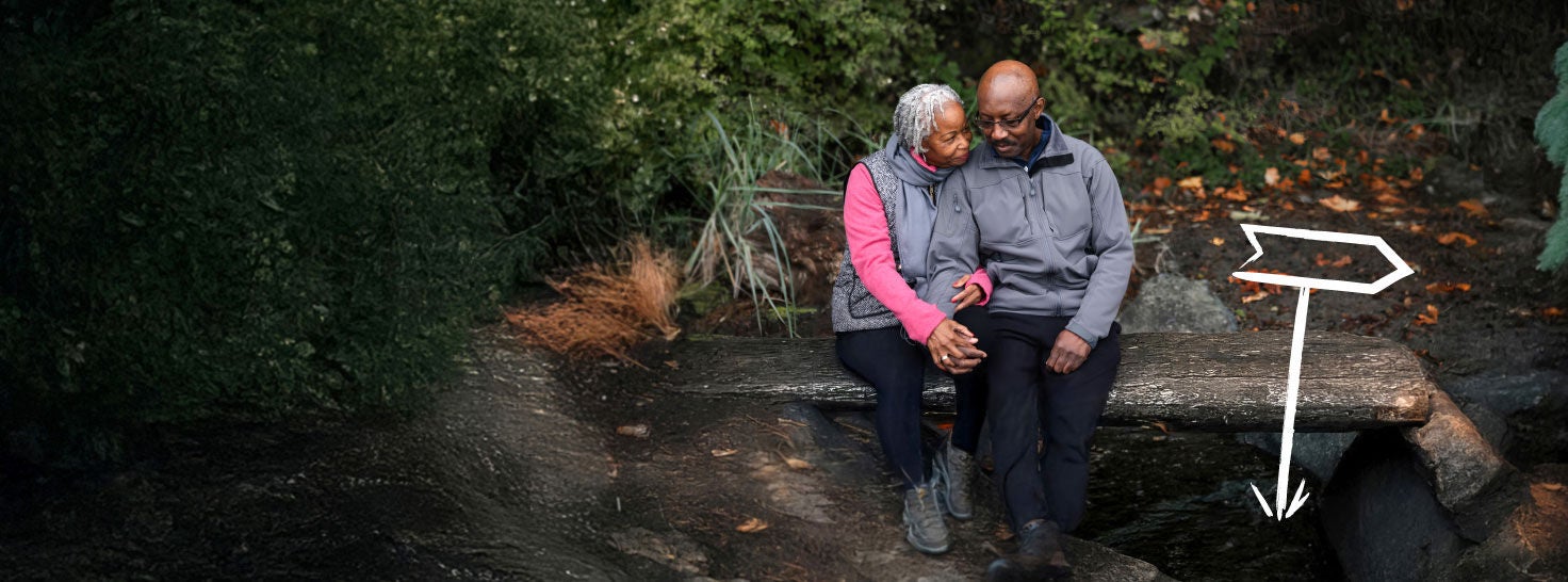 Couple sitting together outdoors on a park bench.