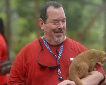 Don holding animal on his arm.