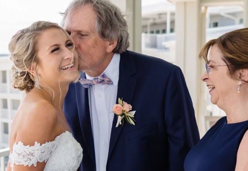 Bride smiling with couple.
