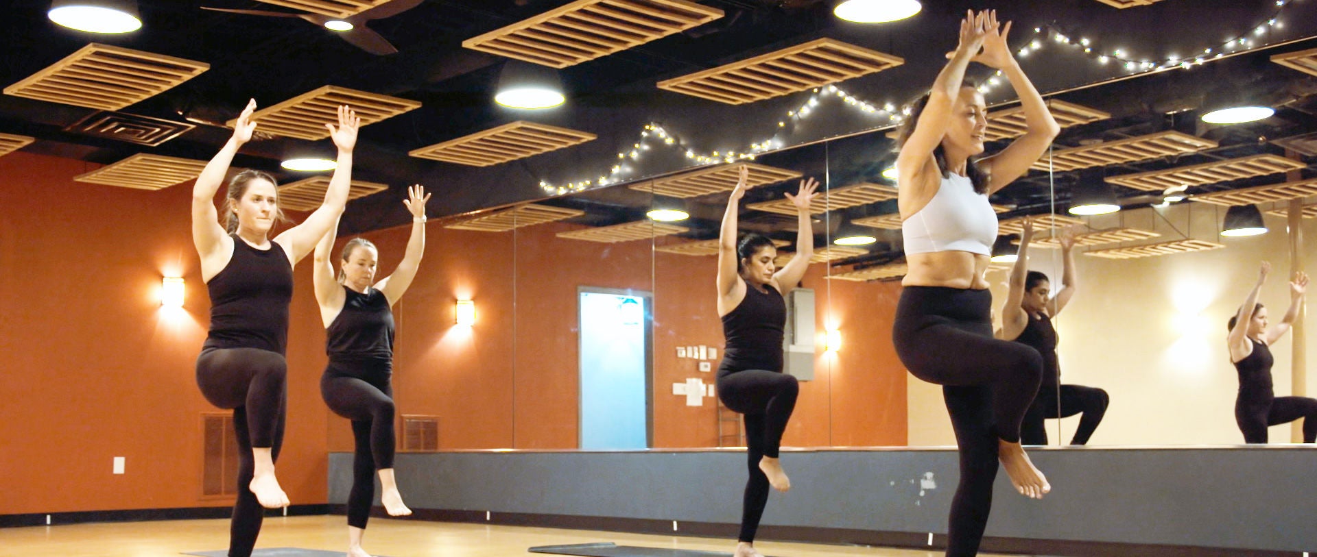 Group of people posing in a yoga studio.