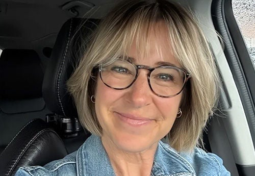 Person smiling while sitting in car.
