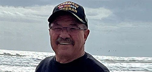 Peter Beckman standing by ocean.